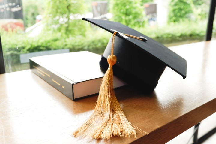 Mortarboard and academic book